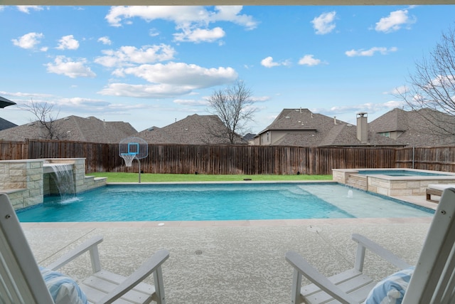 view of swimming pool featuring a patio area, a fenced backyard, and a pool with connected hot tub