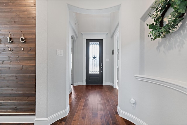 foyer featuring baseboards and dark wood-style floors