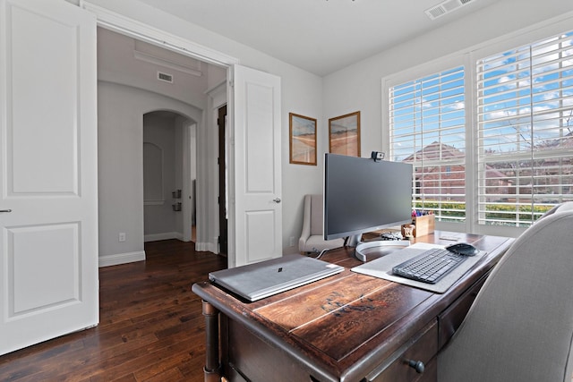 office featuring arched walkways, visible vents, baseboards, and dark wood-style flooring