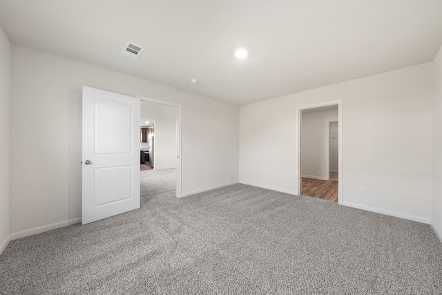 carpeted empty room with visible vents, recessed lighting, and baseboards