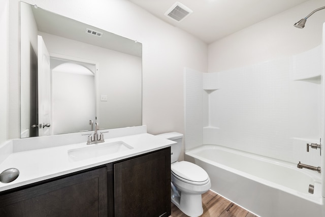 full bathroom with vanity, wood finished floors, visible vents, tub / shower combination, and toilet