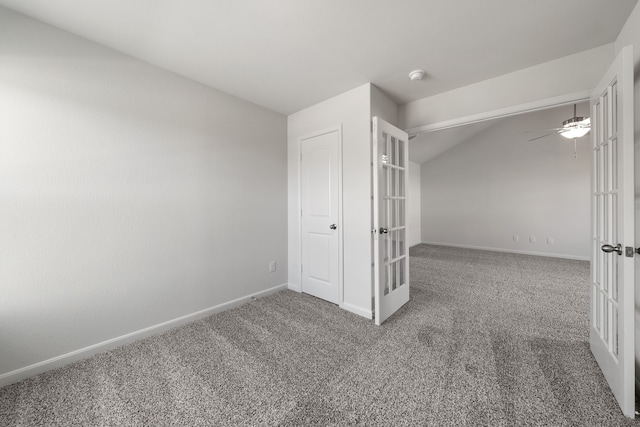 unfurnished bedroom with french doors, baseboards, carpet, and lofted ceiling