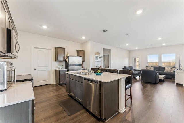 kitchen featuring a breakfast bar area, visible vents, dark wood finished floors, recessed lighting, and stainless steel appliances