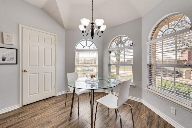 dining space with baseboards, wood finished floors, lofted ceiling, and a chandelier