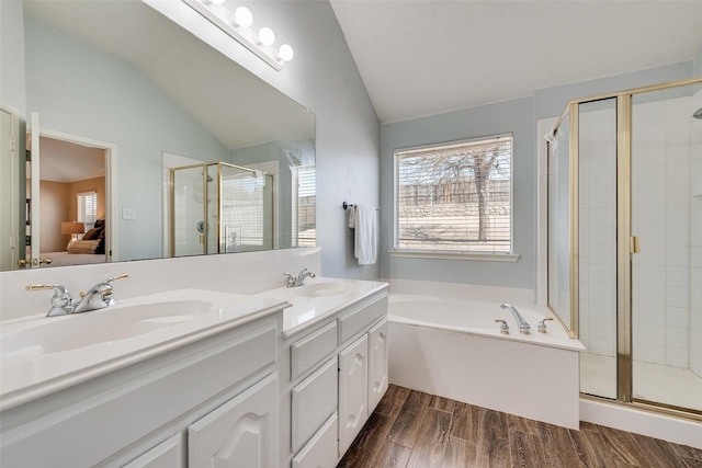 full bath featuring a shower stall, wood finish floors, vaulted ceiling, and a sink