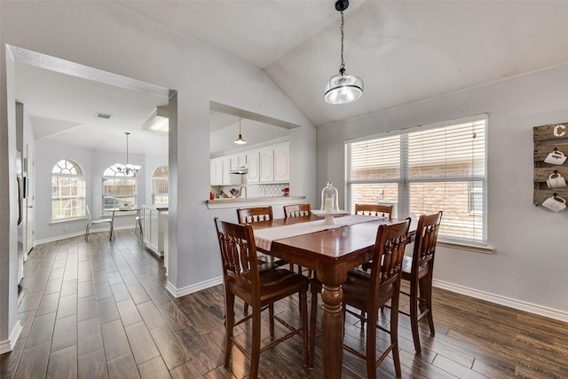 dining space featuring baseboards, lofted ceiling, visible vents, and dark wood finished floors