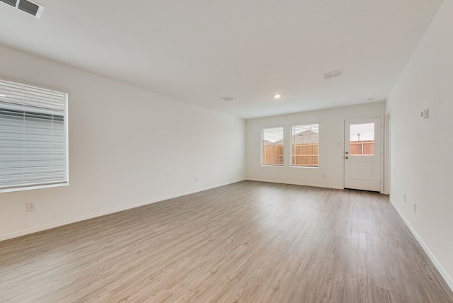 unfurnished room with visible vents, baseboards, and light wood-style floors