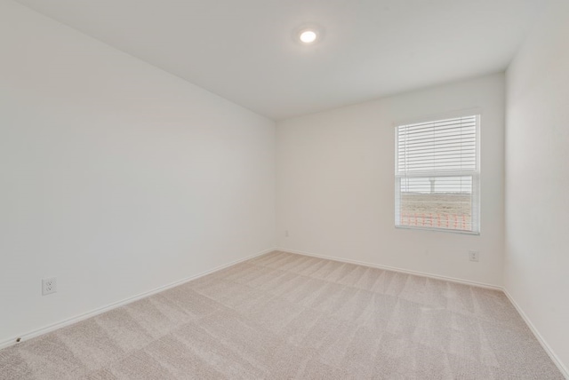 empty room with baseboards and light carpet