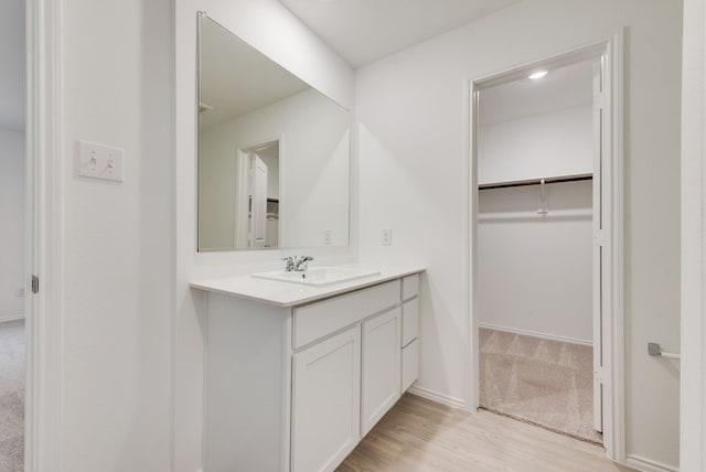 bathroom with baseboards, wood finished floors, and vanity