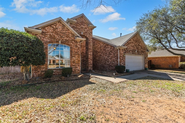 view of front of property with brick siding, driveway, an attached garage, and fence