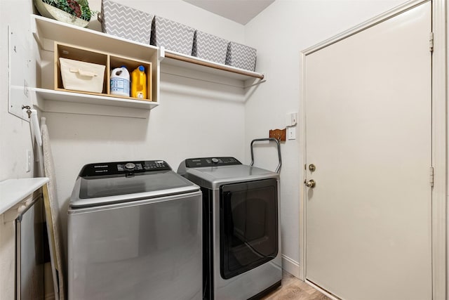 laundry room with baseboards, separate washer and dryer, laundry area, and light wood finished floors