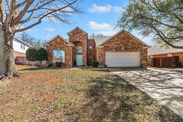 traditional home featuring a garage, fence, brick siding, and driveway