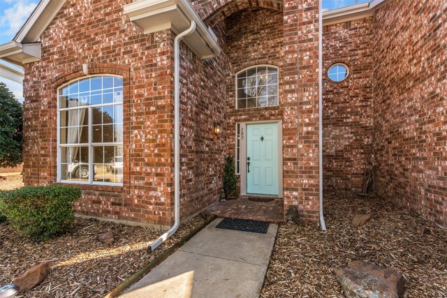 view of exterior entry with brick siding