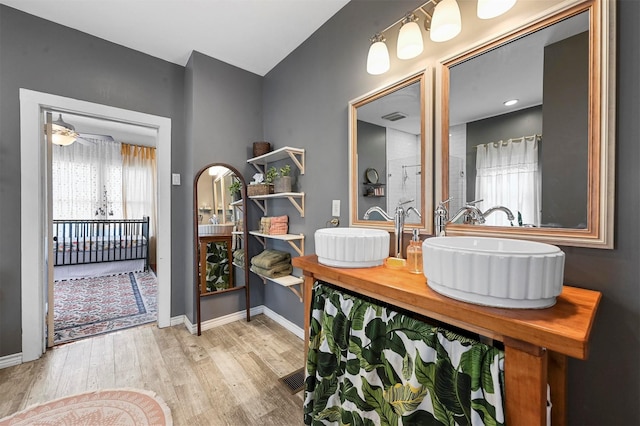 full bathroom with visible vents, baseboards, wood finished floors, and vanity