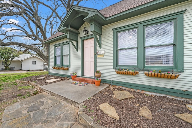 entrance to property with a shingled roof