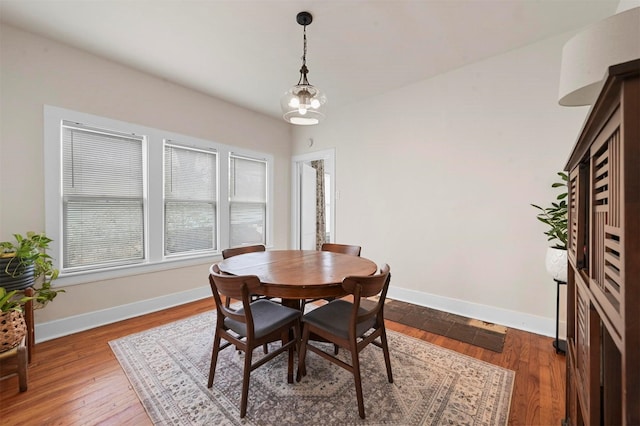 dining area with a notable chandelier, baseboards, and wood finished floors