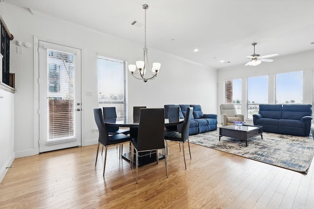 dining space with visible vents, light wood-style flooring, recessed lighting, ornamental molding, and ceiling fan with notable chandelier