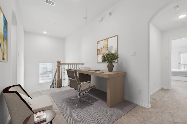 carpeted office space featuring arched walkways, visible vents, recessed lighting, and baseboards