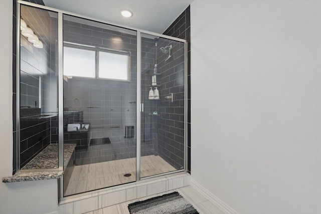 bathroom featuring baseboards and a stall shower