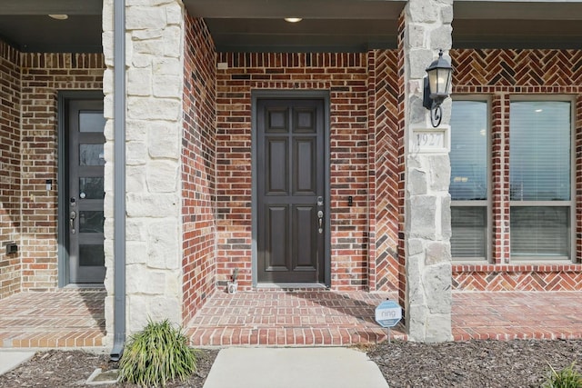 view of exterior entry with brick siding