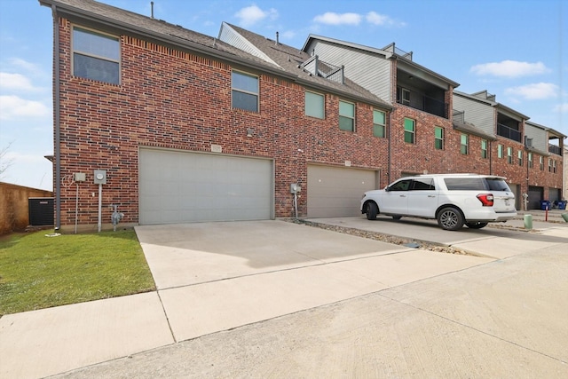 view of home's exterior featuring a garage, brick siding, driveway, and a yard