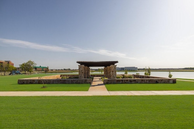 view of property's community featuring a lawn and a water view