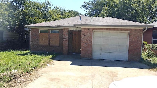 single story home featuring driveway, brick siding, and an attached garage