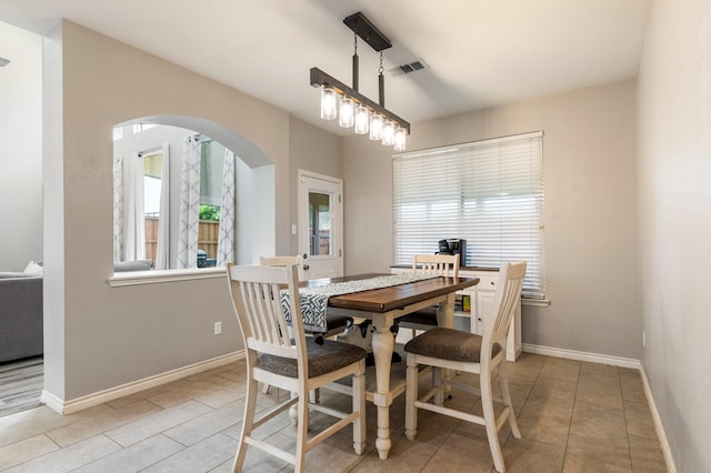 1513 Hidden Cove Ct, Allen, TX 75002 - dining area with arched walkways, healthy amount of natural light, tile patterned floors, and baseboards