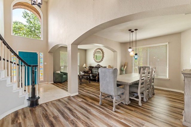 1513 Hidden Cove Ct, Allen, TX 75002 - dining space featuring arched walkways, wood finished floors, stairway, and healthy amount of natural light