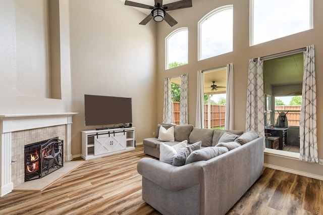 1513 Hidden Cove Ct, Allen, TX 75002 - living area featuring ceiling fan, a towering ceiling, wood finished floors, a fireplace, and baseboards