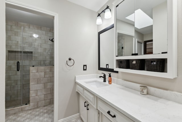 full bath with a skylight, a shower stall, vanity, and baseboards