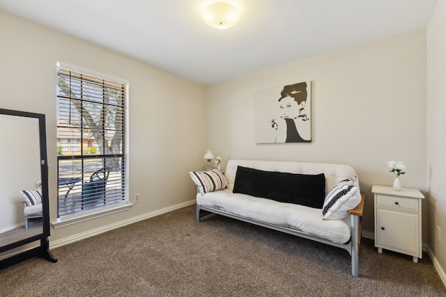 living area featuring dark carpet and baseboards