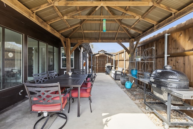 view of patio featuring a gazebo, area for grilling, outdoor dining space, and fence