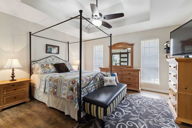 bedroom featuring a ceiling fan, a raised ceiling, and wood finished floors