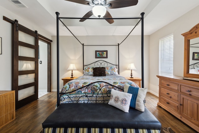 bedroom with a barn door, baseboards, visible vents, and dark wood-style flooring