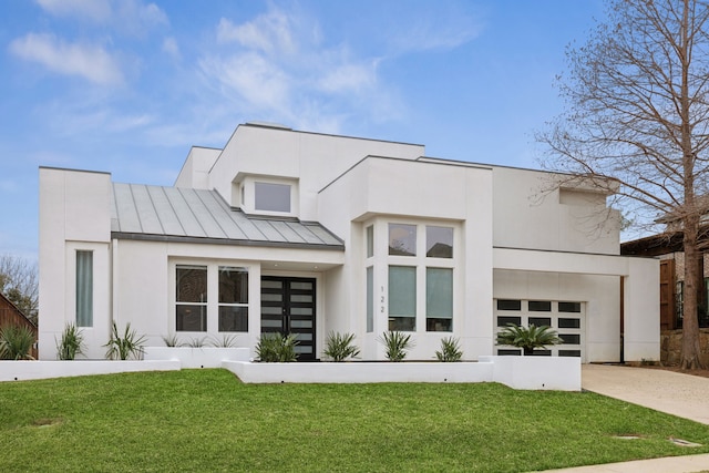 contemporary home with a standing seam roof, a front yard, driveway, and metal roof