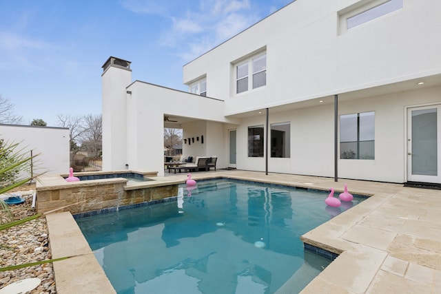 back of house featuring stucco siding, a ceiling fan, outdoor lounge area, an outdoor pool, and a patio area