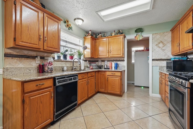 kitchen with a sink, black appliances, brown cabinetry, and light tile patterned floors