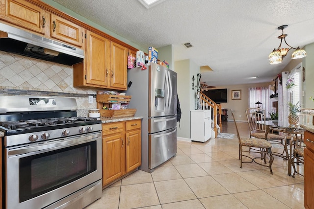 kitchen with tasteful backsplash, visible vents, under cabinet range hood, light tile patterned floors, and appliances with stainless steel finishes