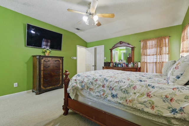 bedroom with visible vents, carpet floors, vaulted ceiling, a textured ceiling, and a ceiling fan