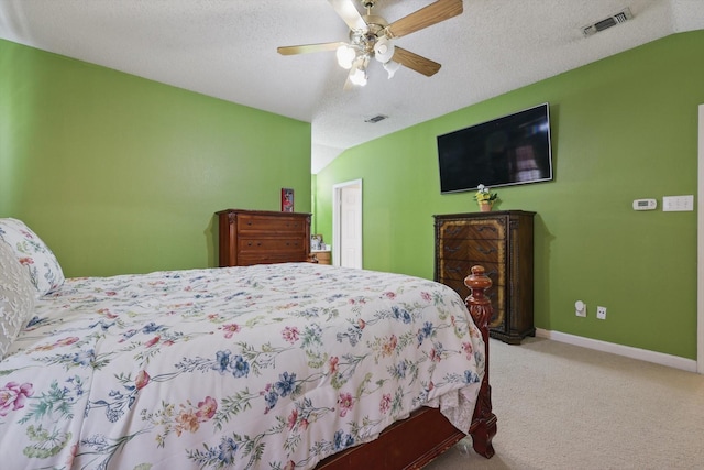 carpeted bedroom featuring visible vents, a textured ceiling, and vaulted ceiling