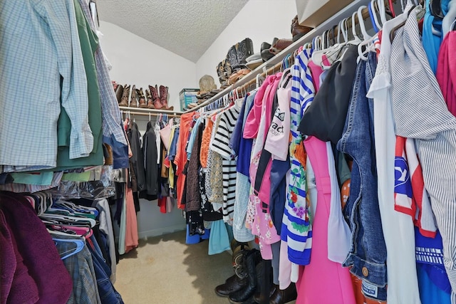 walk in closet with lofted ceiling and carpet flooring