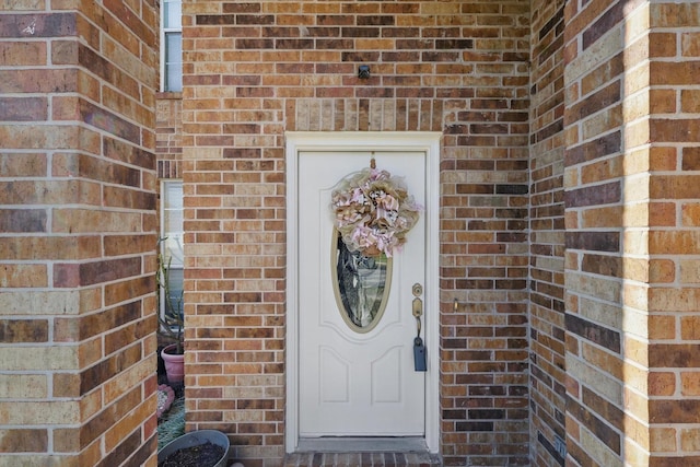 doorway to property with brick siding