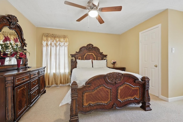 bedroom with a ceiling fan, baseboards, and light carpet