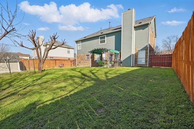 back of house with a yard, a fenced backyard, and a chimney