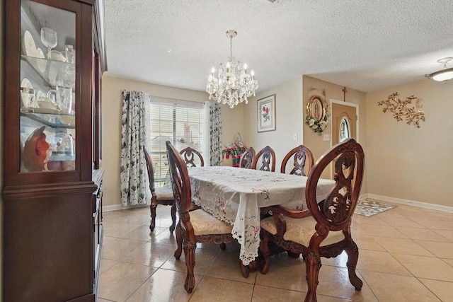 dining area with light tile patterned floors, baseboards, and a textured ceiling