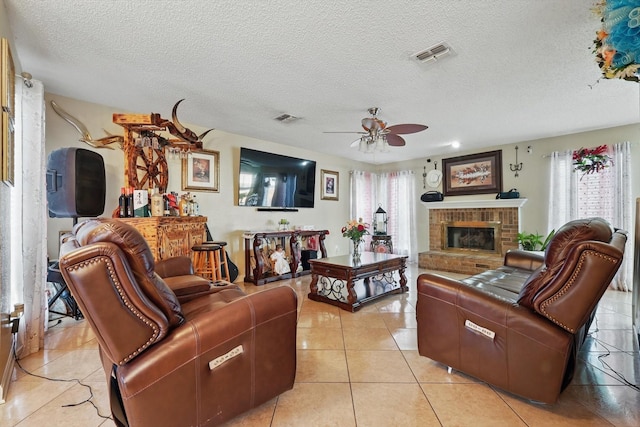 living room with light tile patterned floors, visible vents, a healthy amount of sunlight, and a brick fireplace