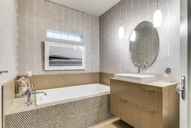 bathroom featuring a bath, tile walls, and vanity