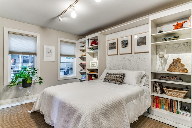 bedroom featuring baseboards and brick floor