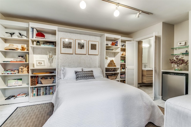 bedroom featuring ensuite bath and freestanding refrigerator